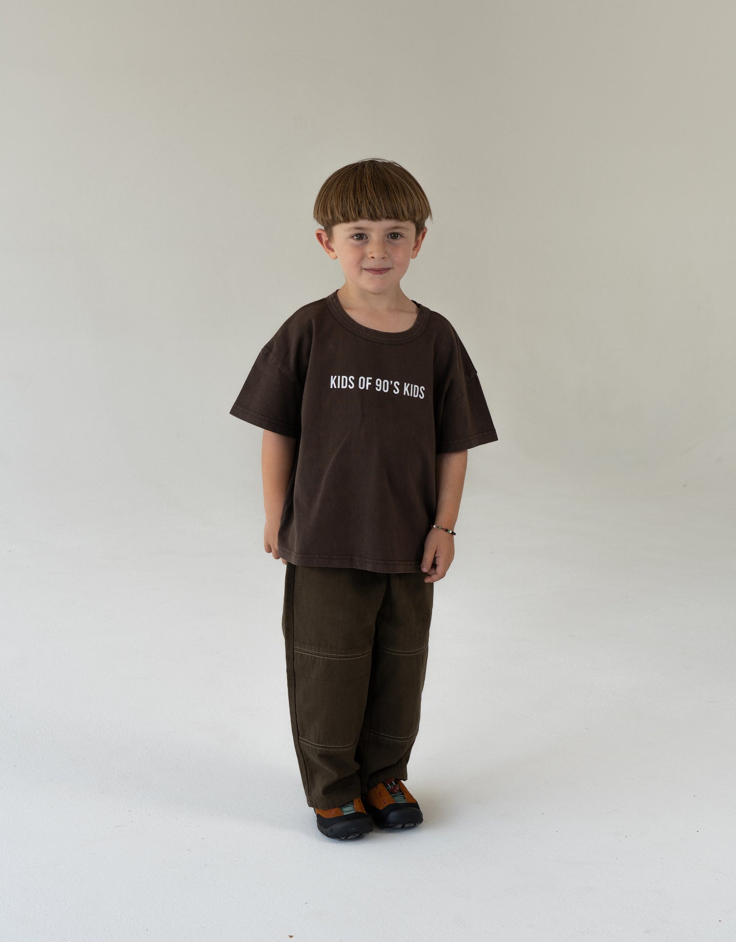 child wearing oversized brown tee with logo and canvas pants for kids 