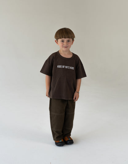 child wearing oversized brown tee with logo and canvas pants for kids 