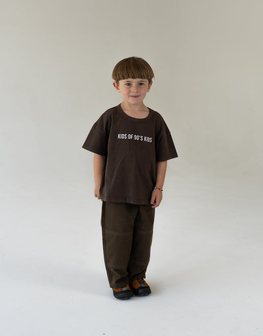 child wearing oversized brown tee with logo and canvas pants for kids 