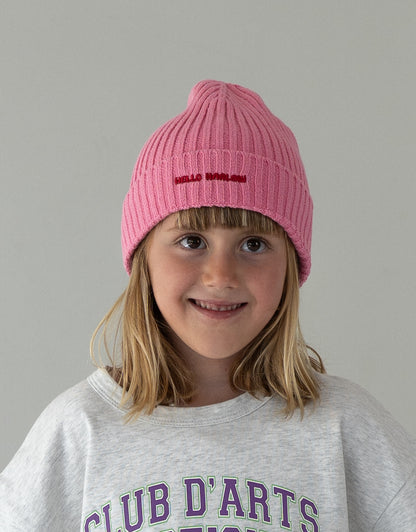 child wearing pink cotton beanie with embroidered logo