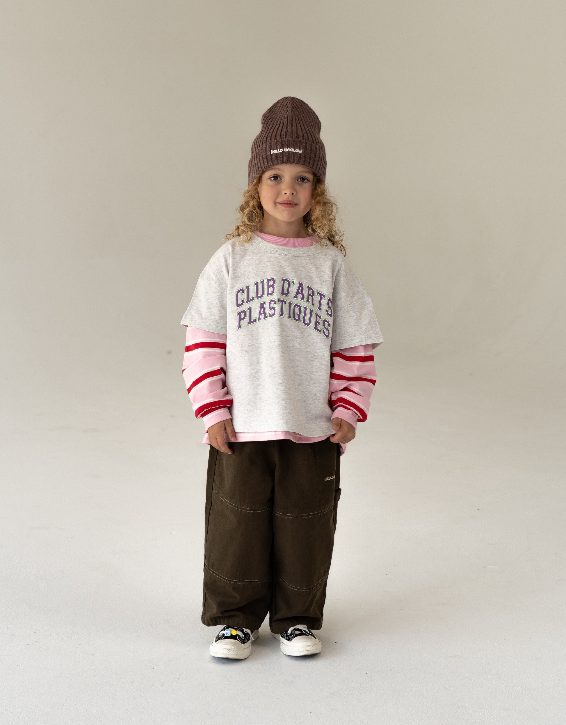 cool kids outfit, girl wearing oversized kids clothes, gray t-shirt layered with pink stripped longsleeve and canvas pants
