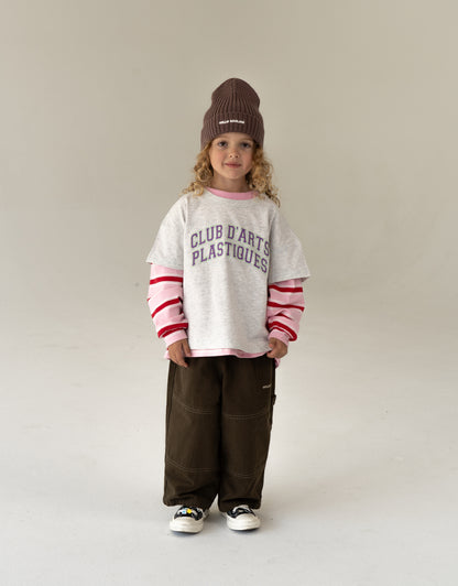 cool kids outfit, girl wearing oversized kids clothes, gray t-shirt layered with pink stripped longsleeve and canvas pants
